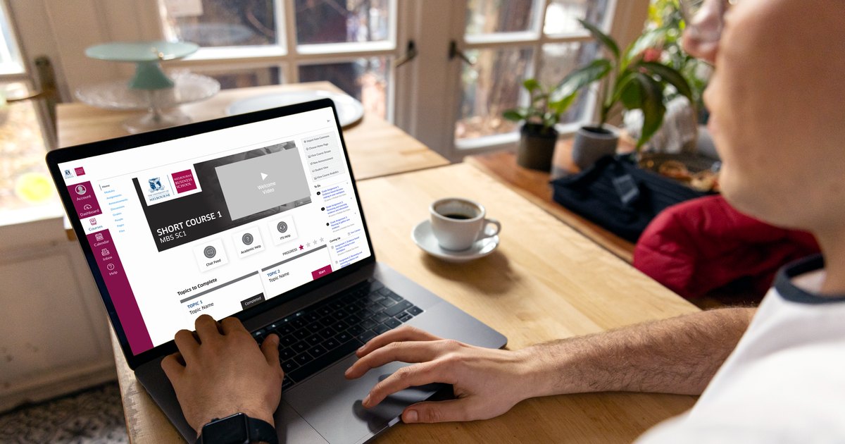 A Melbourne Business School course home page in Canvas, open on a laptop in a café